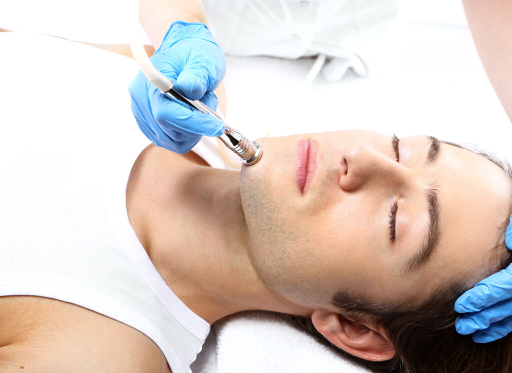 Diamond,Microdermabrasion,,Man,To,A,Beautician.handsome,Man,During,Microdermabrasion,Treatment